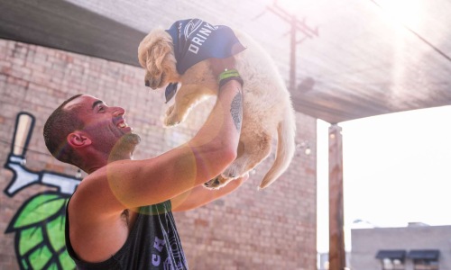 Man holding up small puppy