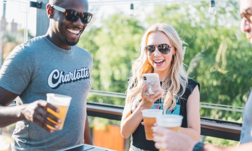 Friends laughing together while drinking beer.